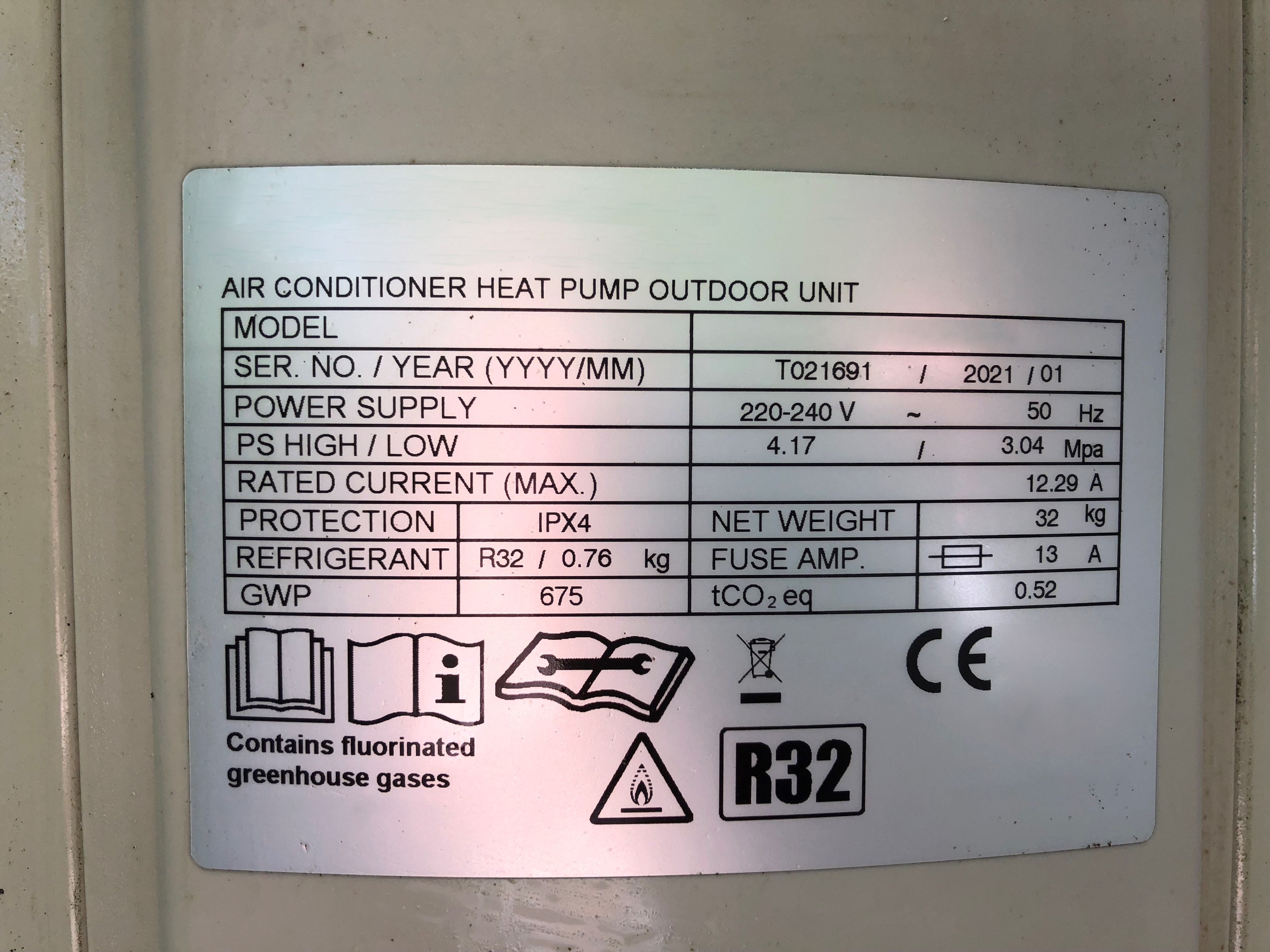 Label on an air conditioner heat pump outdoor unit. The label contains technical specifications including the serial number T021691 and manufacturing date of January 2021. The power supply is listed as 220-240V at 50Hz. Pressure specifications are 4.17/3.04 MPa, and the rated current is 12.29A. Protection level is IPX4. The unit uses R32 refrigerant, with a quantity of 0.76 kg and a GWP of 675. The net weight is 32 kg, and the fuse amperage is 13A. The label also notes the presence of fluorinated greenhouse