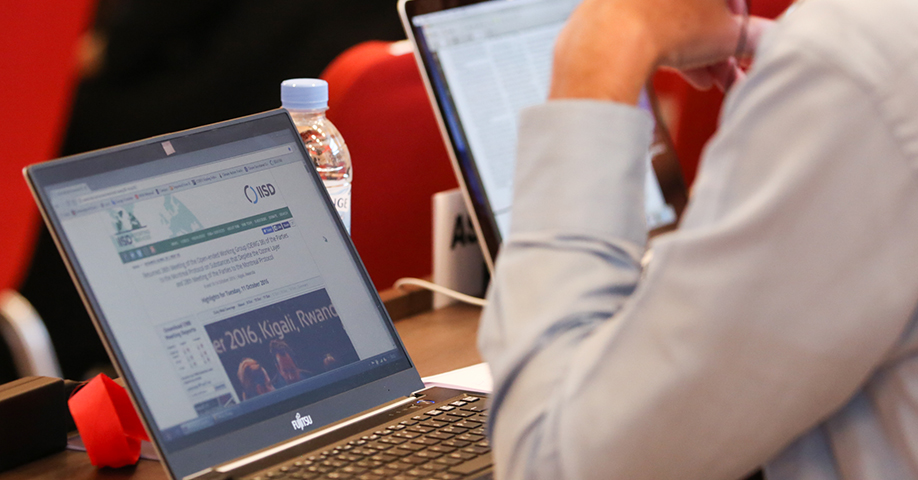 A delegate from the EU at the 28th Meeting of the Parties (MOP 28) to the Montreal Protocol reads the IISD Earth Negotiations Bulletin (ENB) website to keep track of negotiations