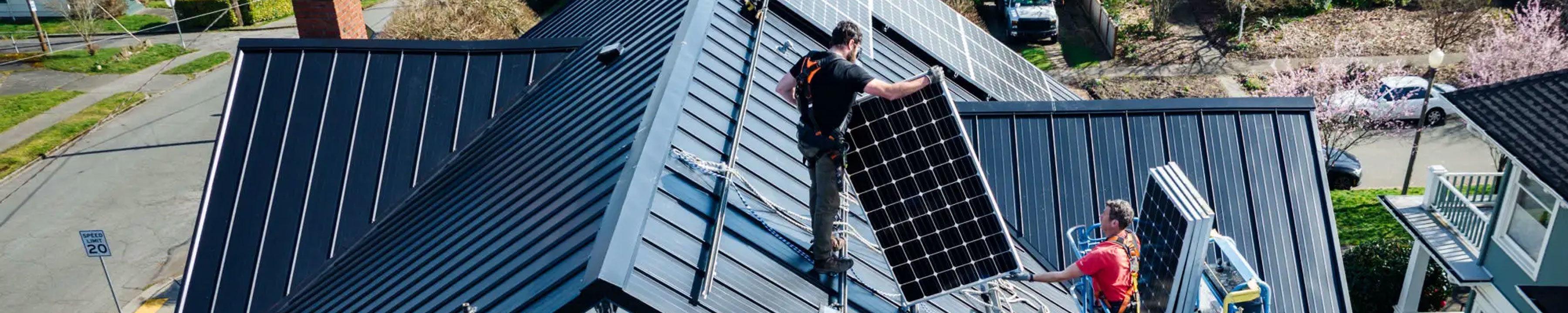 Professional workers installing solar panels on a roof of a house