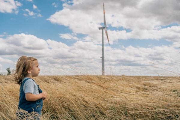 Child with wind turbine in the background