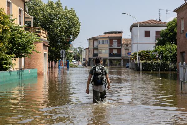 Very wet man walking half submerged in an Italian street 
